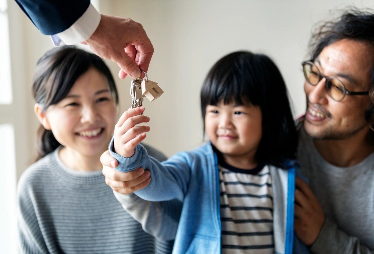 A family is holding keys to their new home.