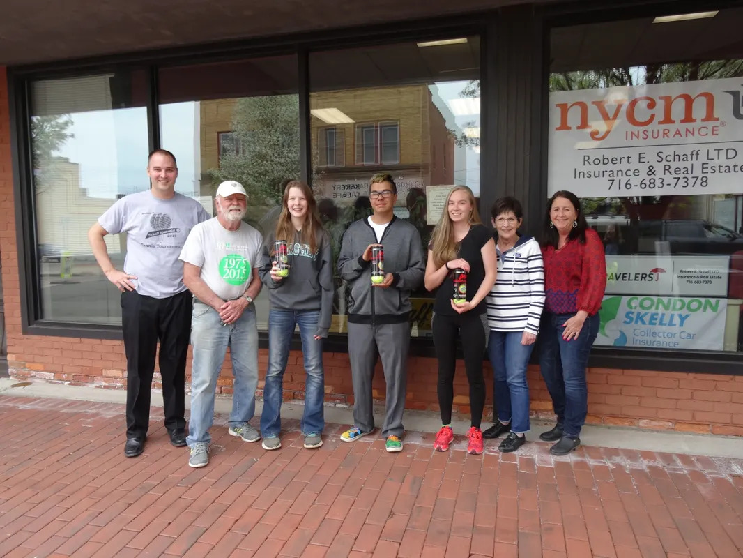 A group of people standing in front of a store.