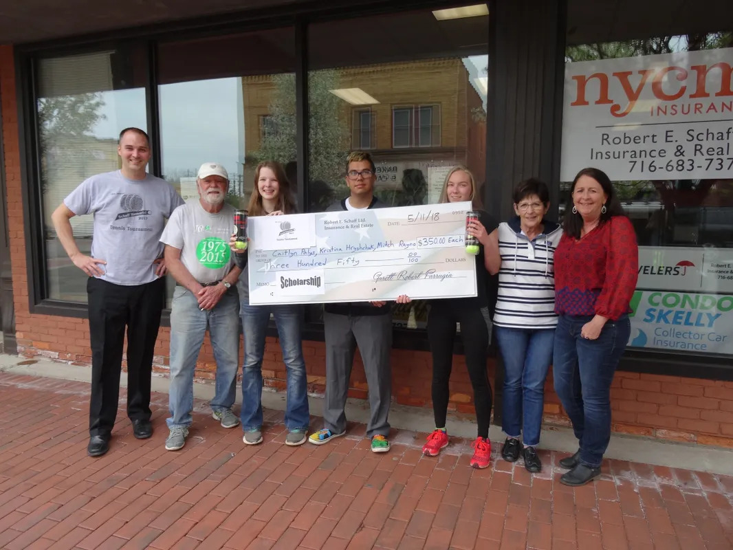 A group of people standing in front of a building holding up a large cheque.